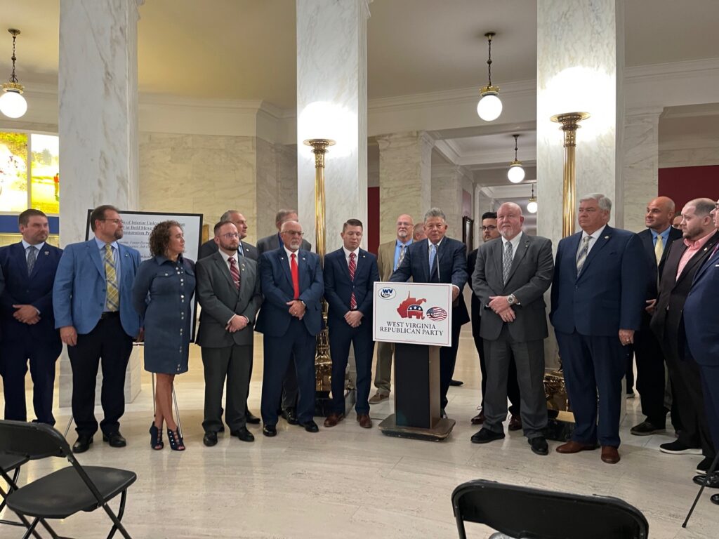 A large group of Republican lawmakers gather in the marbled Capitol rotunda.