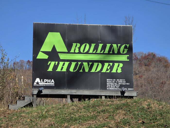Large black sign with Rolling Thunder printed in green.