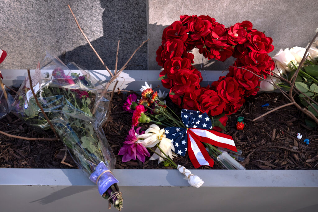 Flowers and a heart shaped bouquet on the sidewalk