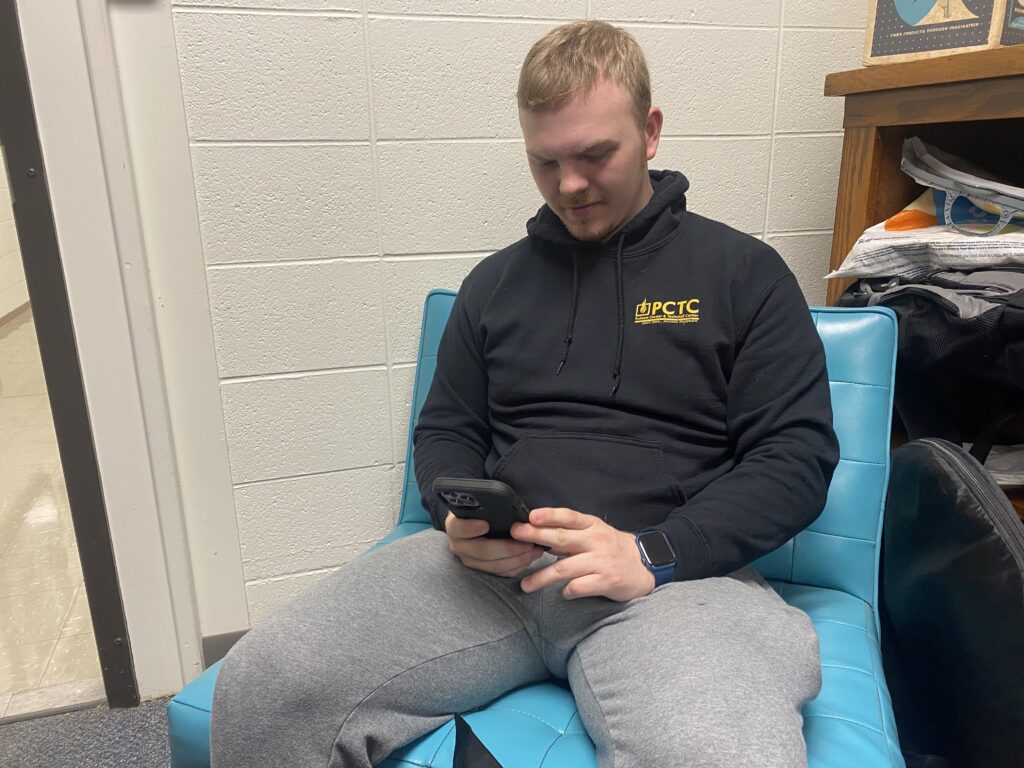 Young man sitting and looking at his phone.