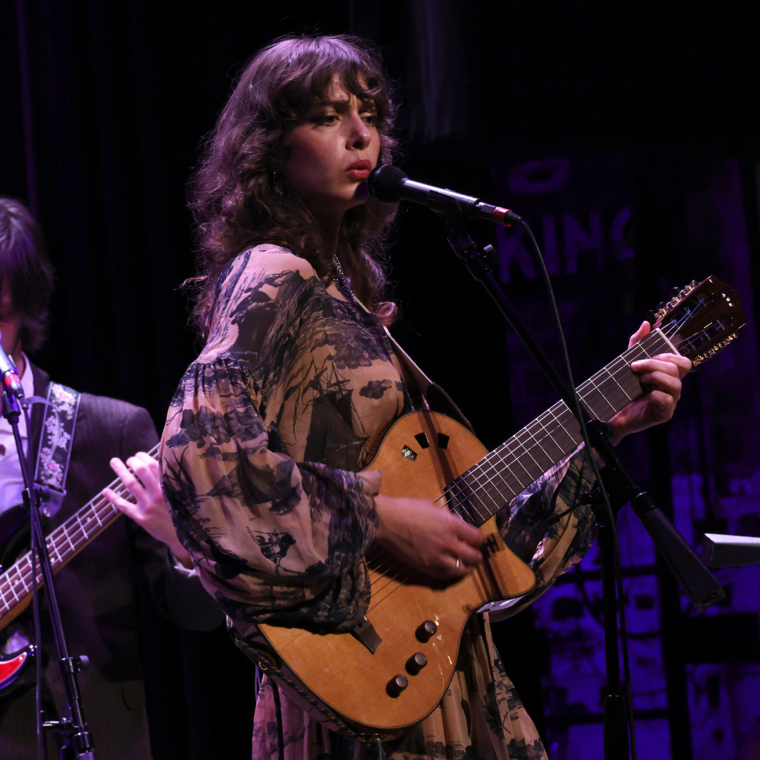 woman sings and plays guitar