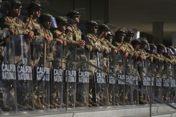 Dozens of National Guard troops are shown in a defensive position outside a federal building in Los Angeles.