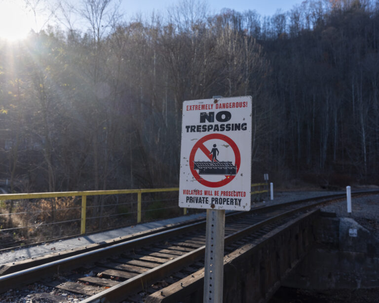 Railroad tracks are seen with a sign that reads, "No trespassing."