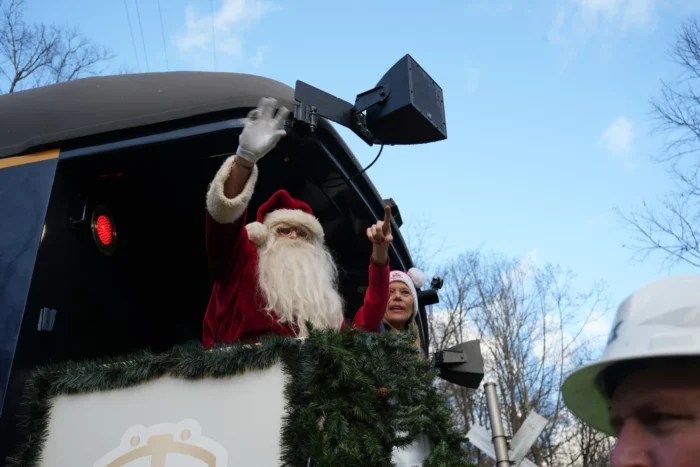 Santa Claus waving from a train car. 