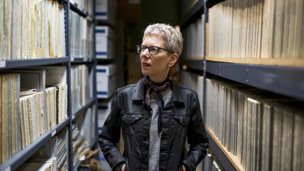 Woman walking through stacks of recordings.