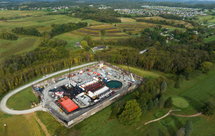 An aerial photo of a hydraulic fracking pad in the middle of the woods.  