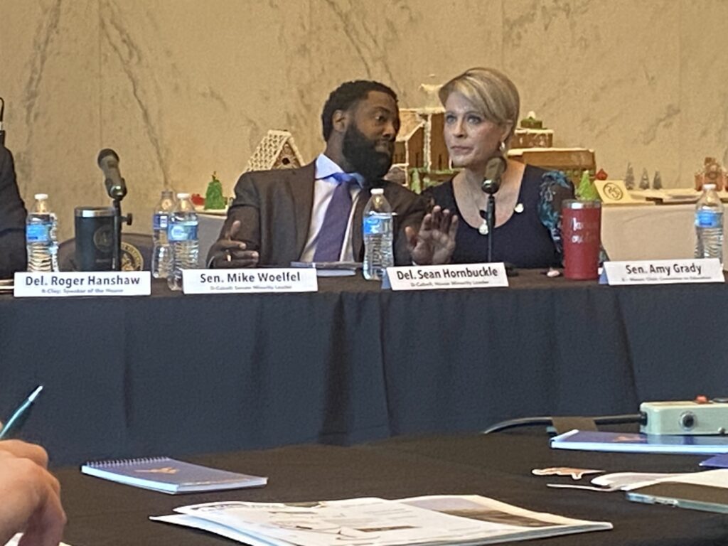 Black man with beard and white woman with blonde hair discussing matters at a table.