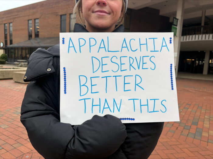 A person holds a sign that reads, "Appalachia Deserves Better Than This."