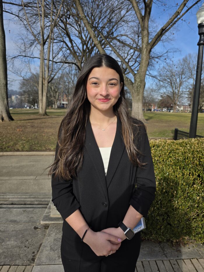 Young girl with long dark hair in a dark suit
