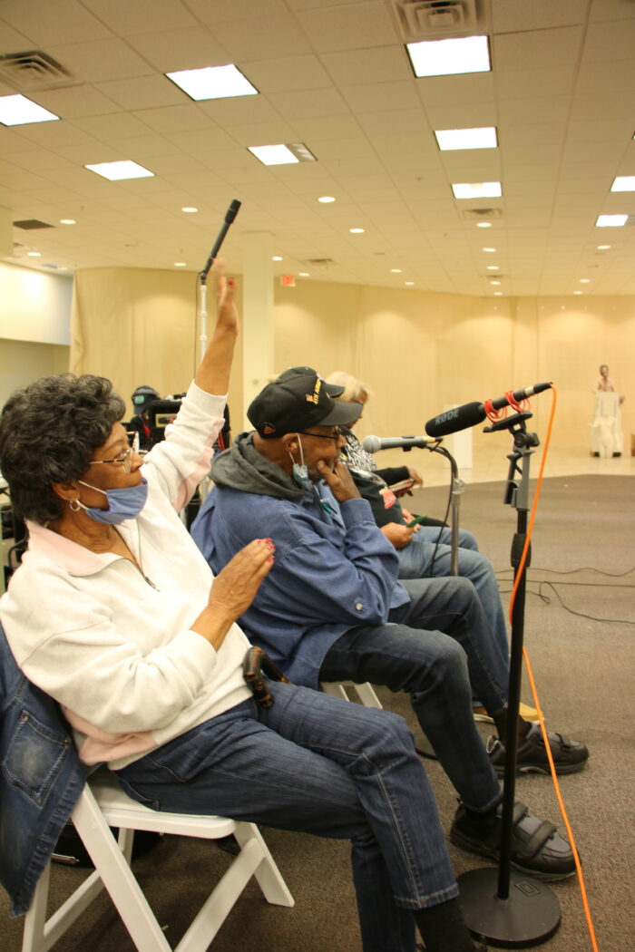 Two adults sit in front of microphones.