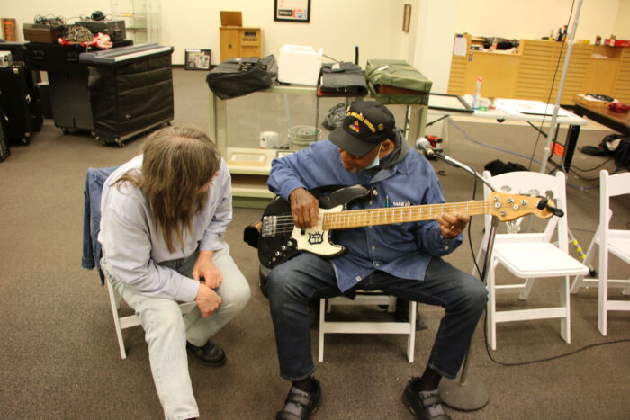 Two men play music together.