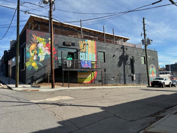 The outside of a building. One of the walls has a mural. 