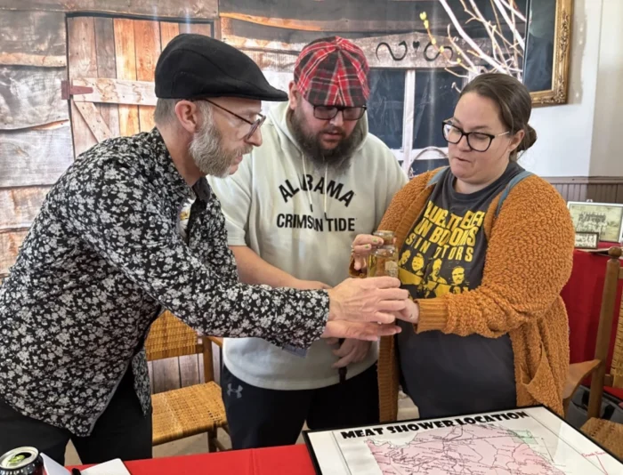 Three people holding the same jar. 