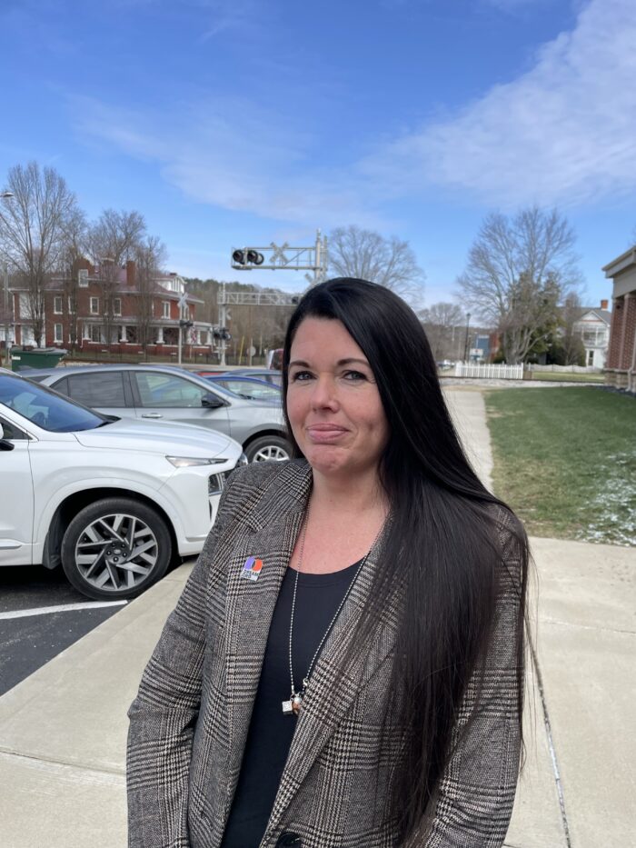Woman with long dark hair in a gray jacket