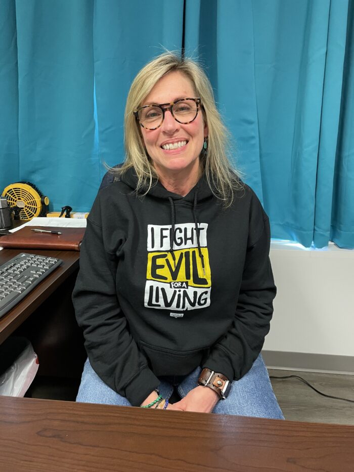 Woman in sweatshirt that reads I Fight Evil for a Living.