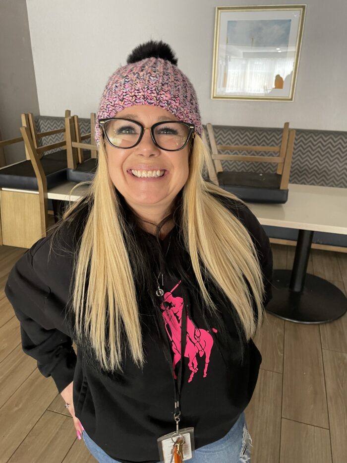 Blond woman in a knit hat smiles for the camera