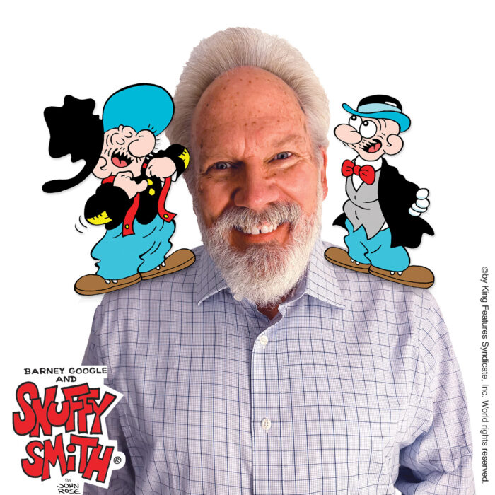 This image contains a white man smiling and two cartoon characters standing on his shoulders. The characters are wearing blue pants, a black shirt and a blue hat. In the bottom left corner, there is a graphic that reads, "Barney Google and Snuffy Smith" by John Rose.