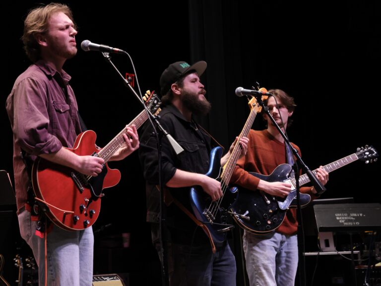 three guys sing and play the guitar