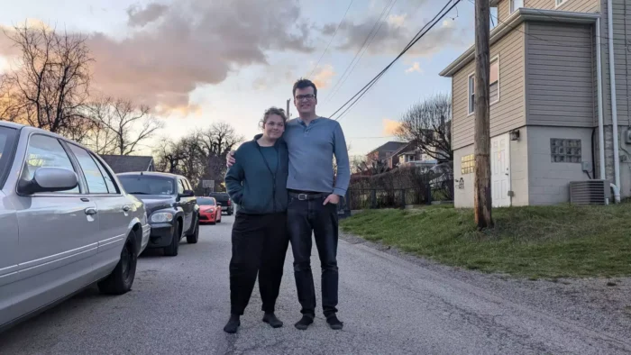 Two people posing in the middle of the street.