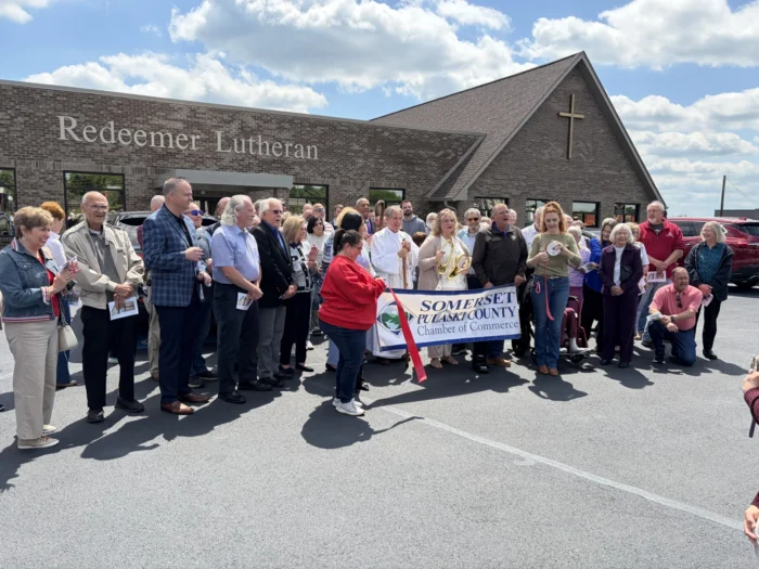 A group of people standing outside a church holding a banner.