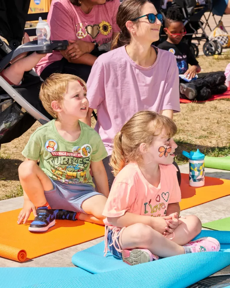 A woman and two children, a boy and a girl. The little girl has a butterfly painted on her face.