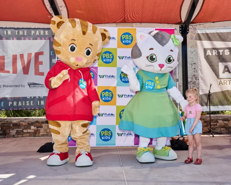 Daniel Tiger and Katerina Kittycat with a small girl.