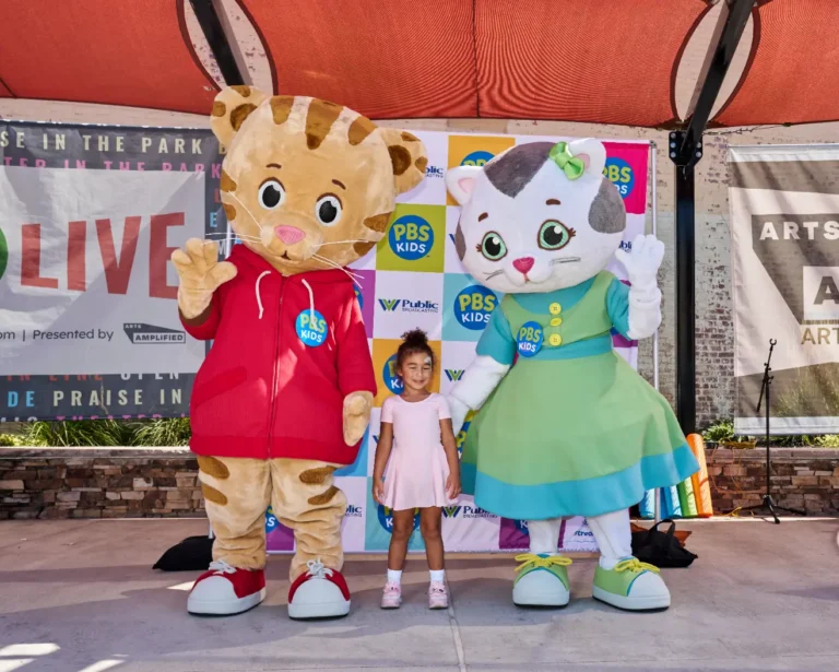 Daniel Tiger and Katerina Kittycat with a small girl.