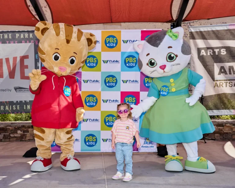 Daniel Tiger and Katerina Kittycat with a small girl.