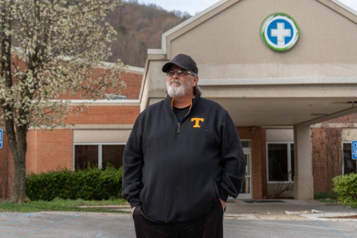 A white man standing in front of a hospital.