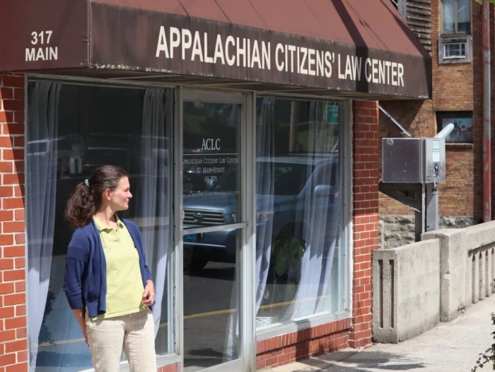A white woman standing outside of a building. The building's awning reads, "Appalachian Citizens' Law Center."