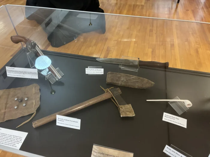 A collection of tools behind a glass exhibit.