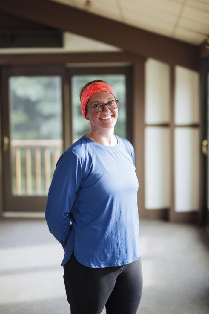 Woman in blue t-shirt and red head band looks at camera