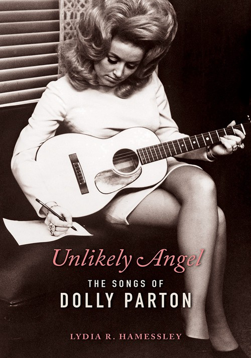 The cover of a book called "Unlikely Angel: The Songs of Dolly Parton" by Lydia R. Hamessley. The black-and-white photo includes a white woman sitting on a couch holding guitar. She is looking down writing on a piece of paper.
