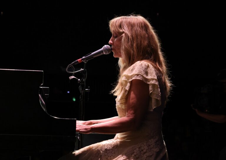 woman with blond hair plays piano