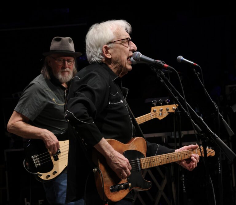 Bill Kirchen plays the guitar and sings into mic