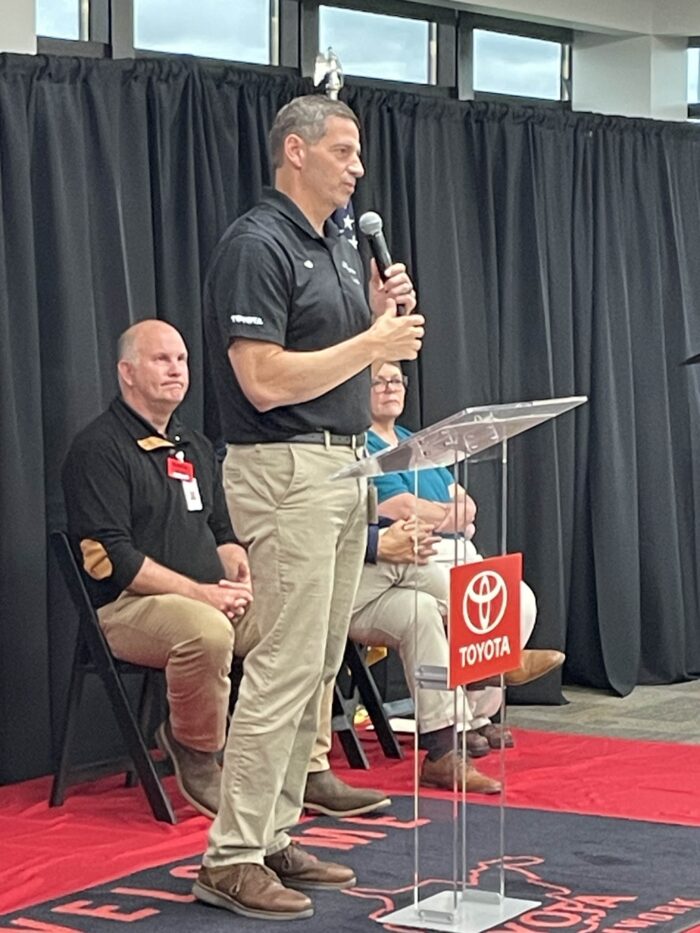 A man speaks into a microphone at an event.