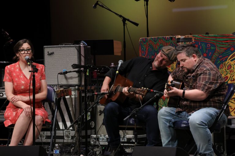three musicians perform on stage