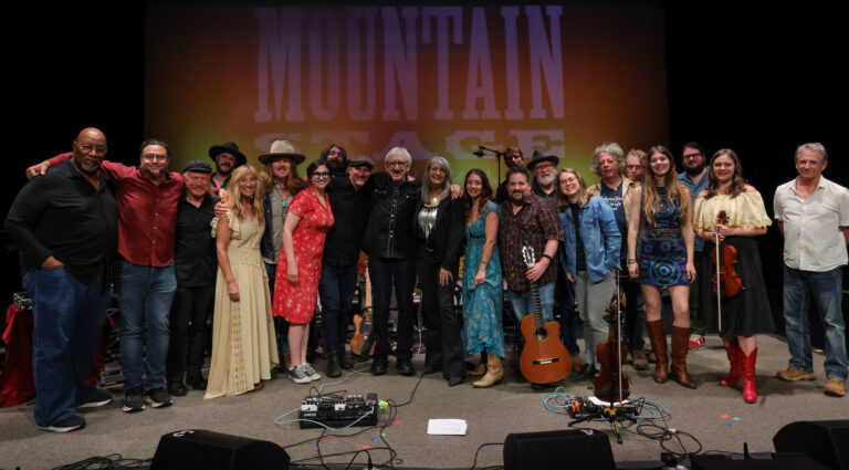 a large group of musicians pose for photo on stage
