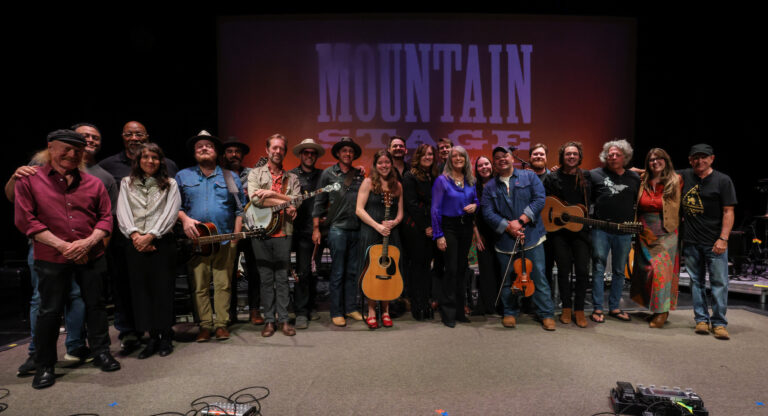 musicians stand on stage and pose for photo