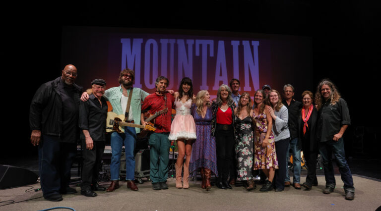 a group of musicians pose for a photo on stage