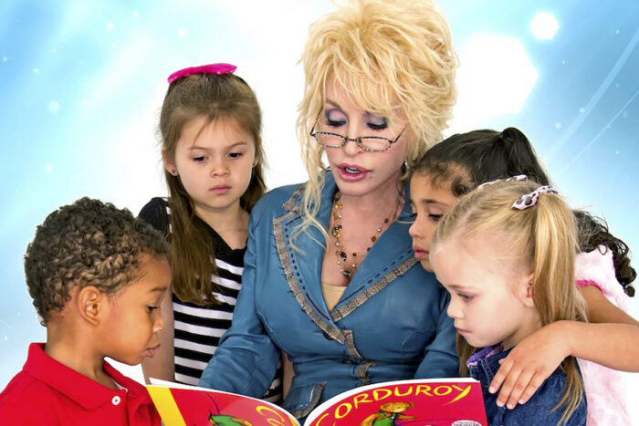 blond haired woman reads to four children