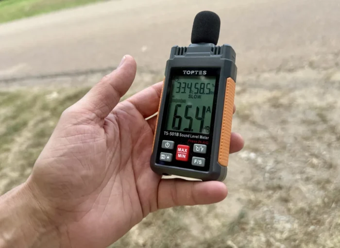 A photo of a hand holding a sound level meter. 