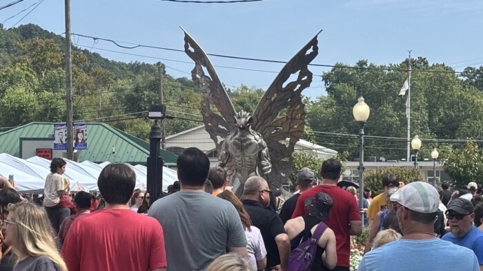 A crowd looks on at the iconic Mothman statue in Point Pleasant, WV.